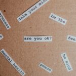 Cut-out words promoting mental health awareness on cardboard background.